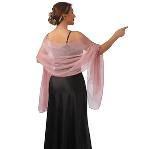Elegante scialle da sera velato oro rosa con trama luccicante drappeggiato sulla modella.