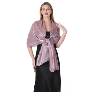 Elegante scialle in raso perlato rosa polvere drappeggiato su un abito da sera nero.