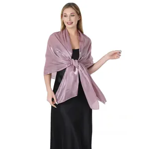 Elegante scialle di raso rosa antico luccicante sopra un abito da sera nero per matrimoni
