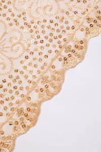 Close-up of golden sequin embroidered mesh lace fabric with elegant plum pattern