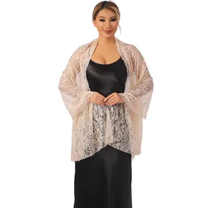 Detailed shot showing the delicate floral lace texture of the apricot shawl