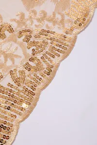 Detailed macro view of gold sequins and embroidery on a high-end luxury mesh shawl