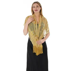 Close-up of elegant gold sequin embroidered shawl with fringe worn on model