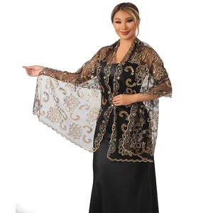 Close-up of elegant black mesh shawl with gold sequin lotus embroidery for evening dress