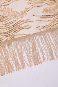 Macro detail of gold sunflower sequins and long fringe on elegant evening shawl