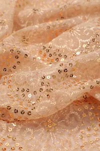 Detailed view of elegant champagne mesh fabric with gold sequins for evening shawl