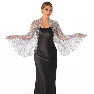 Detail view of sparkly silver sequined shawl worn over a black formal evening gown.