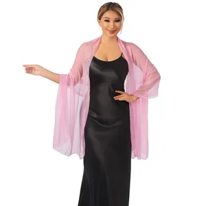 Elegante scialle di tulle rosa velato indossato su un abito da sera in raso nero.