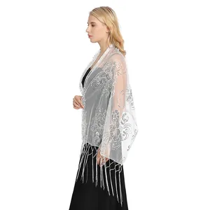 Detailed side view of a white mesh shawl featuring silver sequins and elegant long tassels.