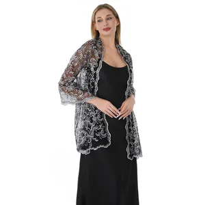 Elegantly draped silver sequin lace shawl detail on a model in a black dress
