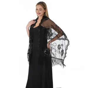 Detailed view of black lace shawl featuring sequin embroidery and long fringe tassels