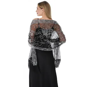 Vue arrière d'un élégant châle en maille noire avec motifs floraux pailletés d'argent