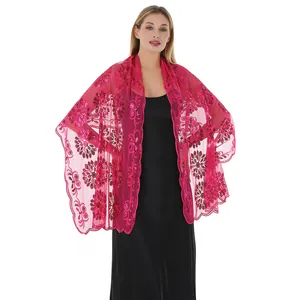 Dettaglio di uno scialle in pizzo ricamato con paillettes magenta e motivi floreali da sera