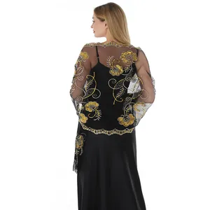 Detail view of black sheer shawl with elegant gold floral sequin embroidery and tassels