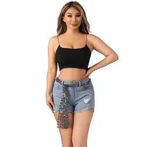 Detail view of a shimmering silver sequined belt accessory worn with denim shorts.