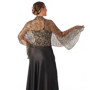 Detail of golden sequin mesh shawl worn over black satin evening dress for parties