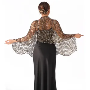 Close-up detail of shimmering gold sequined mesh shawl worn with black evening dress