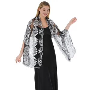Vista dettagliata di un elegante scialle in pizzo con fiori di paillettes argento per abiti.