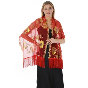 Detail showing gold sequin flower embroidery and red fringes on a mesh shawl for formal wear.