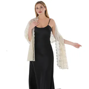 Detail view of champagne lace shawl with floral sequin embroidery on model