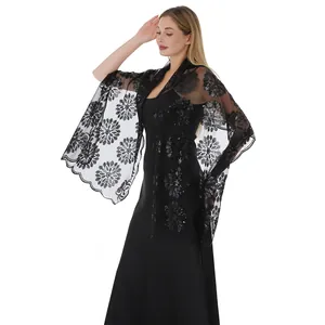 Vista dettagliata dell'elegante scialle in pizzo nero con intricati ricami floreali di paillettes.