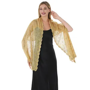 Close-up of elegant gold lace shawl with sparkling sequins and floral embroidery