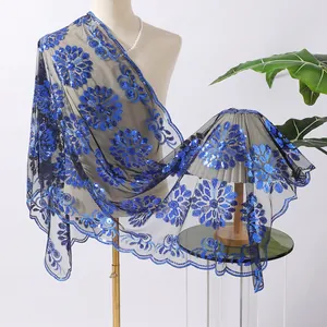 Dettaglio di elegante scialle floreale con paillettes blu reale su rete nera