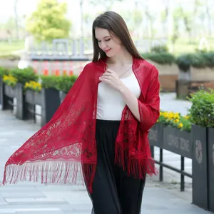 Detailed view of elegant red lace shawl with floral embroidery and tassel fringe