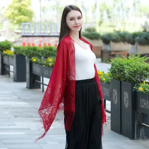 Elegant red lace bridal shawl scarf with fringe details worn by an outdoor model