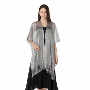 Shimmering silver metallic wrap shawl with elegant fringe detail on female model