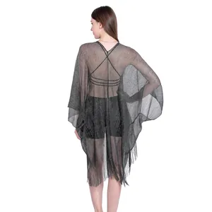 Back view of a shimmering black metallic shawl with long fringe and open sleeves