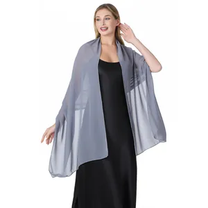 Châle en mousseline de soie gris drapé sur une robe de soirée noire montrant la texture