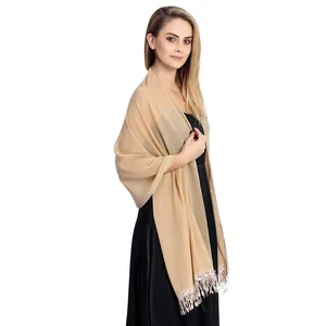 Elegant beige chiffon shawl with intricate lace trim and fringe details on model