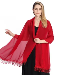 Detailed view of lightweight red chiffon shawl with delicate lace and tassel trim