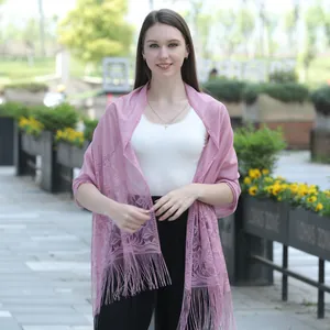 Macro view of pink floral lace shawl with fringe details and delicate patterns