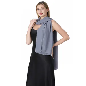 Élégant châle en mousseline grise sur une robe en satin noir pour les soirées.