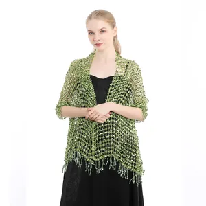 Detailed shot of a light green sequined mesh shawl with elegant tassel fringe details