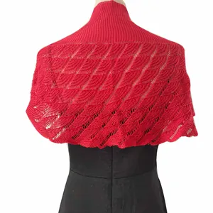 Detail showing red knitted shawl with hollow fishtail texture on black mannequin dress