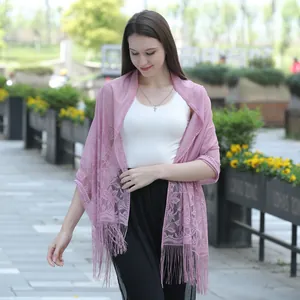 Detailed view of sweet pink lace shawl with intricate floral patterns and tassels