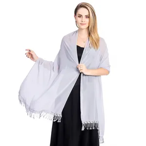 Elegant light grey chiffon shawl with lace fringe worn over a black evening dress