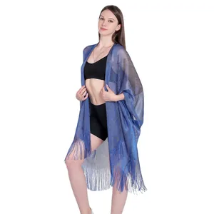 Close-up of the shimmering blue metallic yarn texture and fringed hem of the shawl