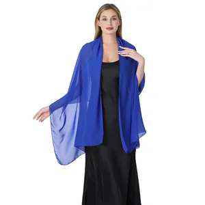 Étole de soirée légère en mousseline bleu roi portée sur une robe en satin noir.