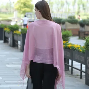 Back view of a sweet pink lace shawl with delicate floral patterns and tassels
