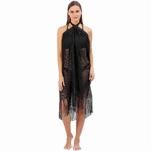Close-up detail of black lace beach cover-up featuring geometric patterns and fringe tassels