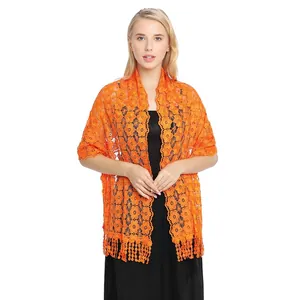 Detail showing vibrant orange embroidered lace shawl with delicate floral patterns.