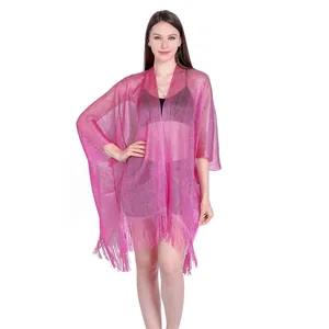 A pink metallic shimmery shawl with fringe details worn over a black bikini against white backdrop