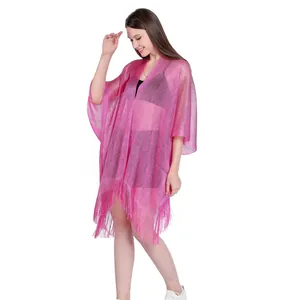 Macro view of pink shimmery fabric with fringe detail on a stylish beach cover-up kimono.
