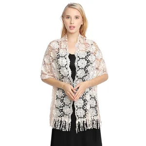 Detail view of an elegant lace evening shawl with intricate floral embroidery and tassels.