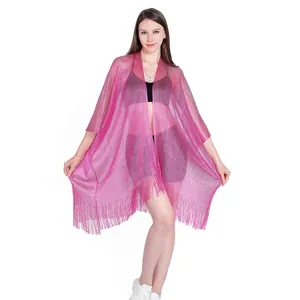 Detail of sheer magenta shimmering poncho with fringe hem and metallic thread effect