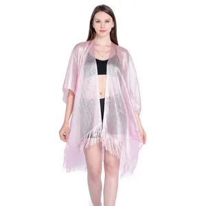 Model wearing a pink metallic mesh shawl with fringe detail over black swimwear